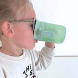 Kind drinkt moeiteloos uit magische drinkbeker met 360° drinkrand, ideaal voor zelfstandig drinken.