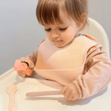 Peuter met de silicone lepels in de handjes. Het voelt voor hun heel fijn en gemakkelijk aan.