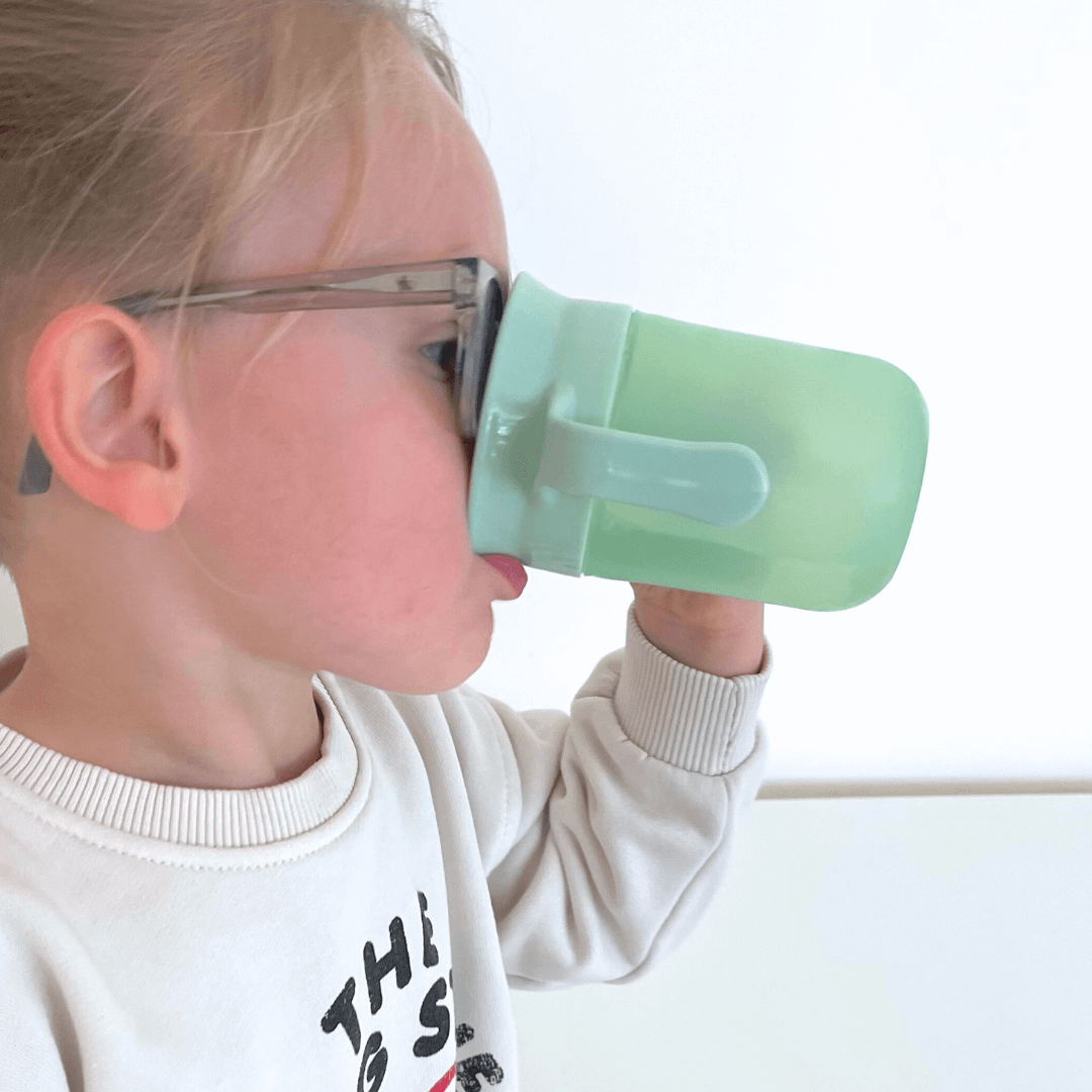 Kind drinkt moeiteloos uit magische drinkbeker met 360° drinkrand, ideaal voor zelfstandig drinken.